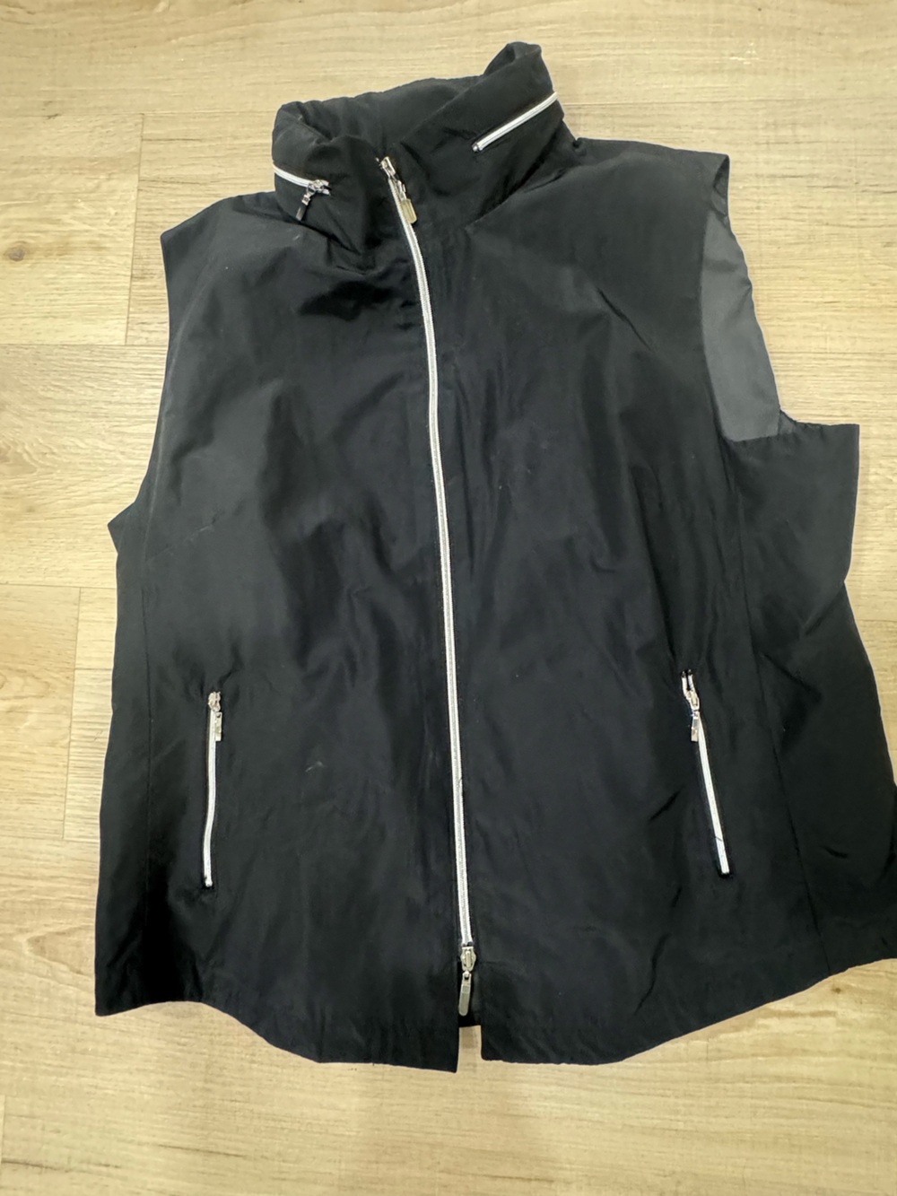 Black Sleeveless Zip-Front Vest with Stand Collar that has a hidden hood.